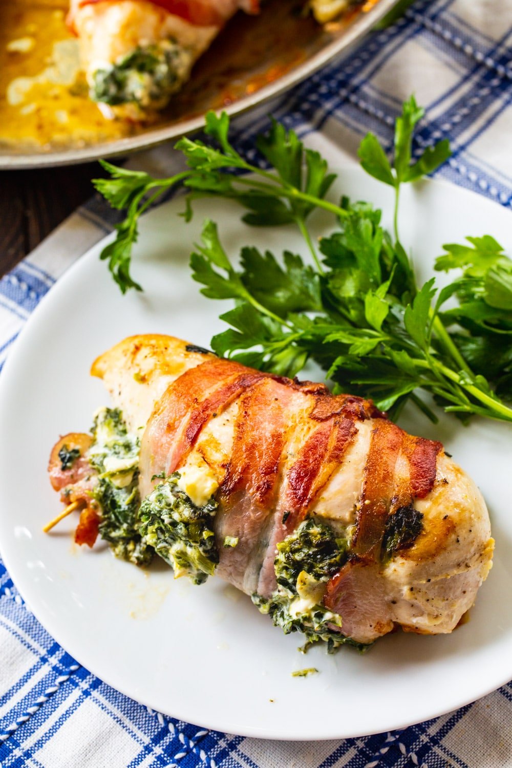 Bacon Wrapped Spinach and Feta Stuffed Chicken breast on a plate.