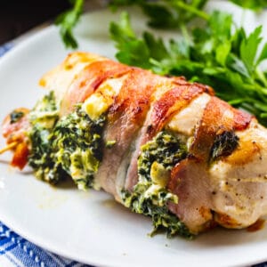 Bacon Wrapped Spinach and Feta Stuffed Chicken Breast on a plate with salad.