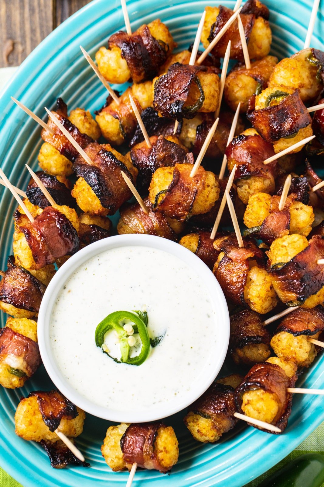 Jalapeno Bacon Tater Tots with bowl of dipping sauce on serving plate.