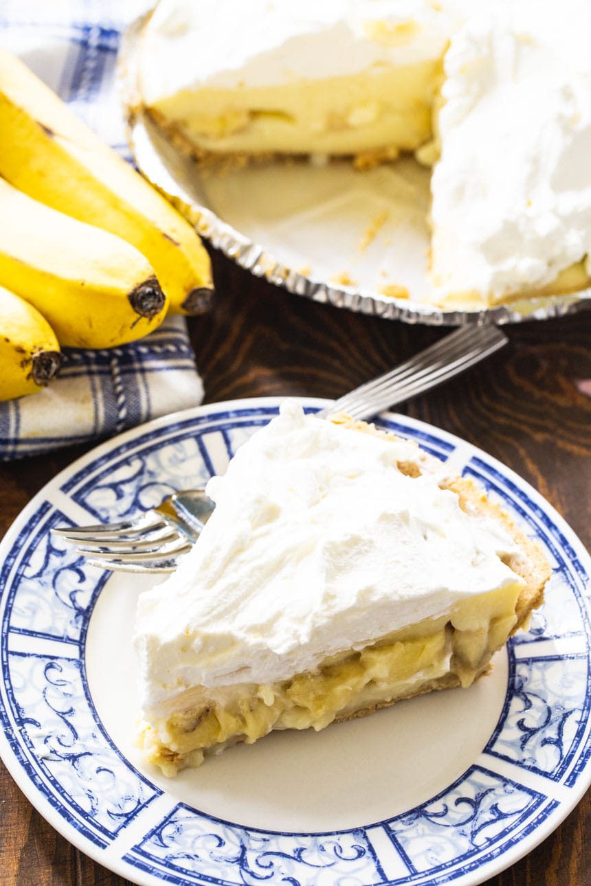 Slice of Banana Pudding Pie with bananas in background