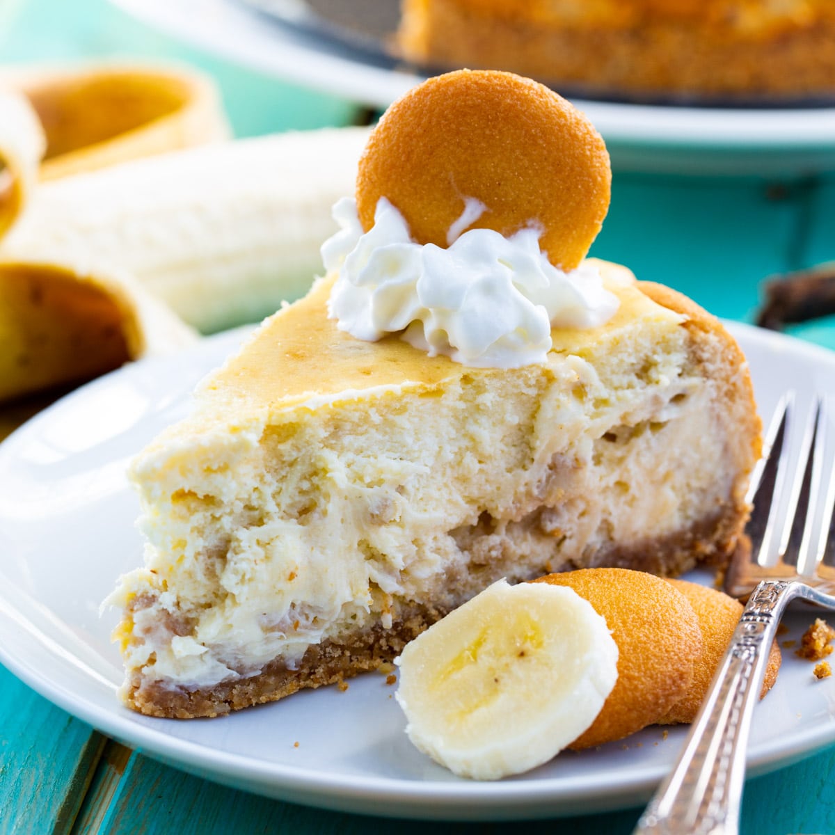 Slice of Banana Pudding Cheesecake topped with whipped cream and a vanilla wafer.