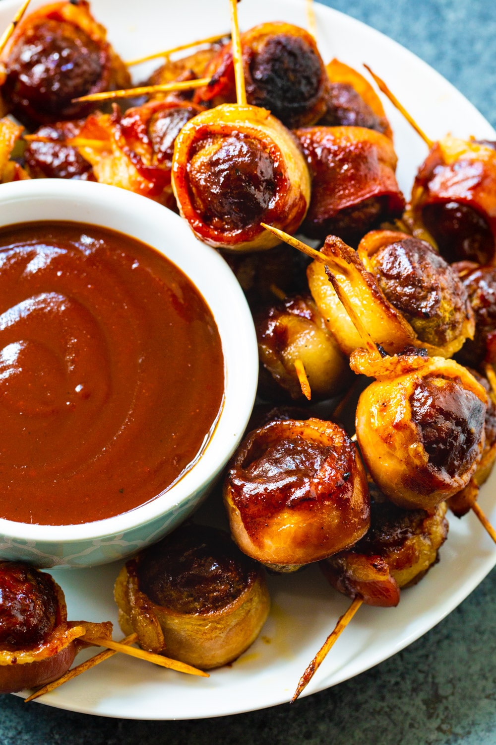 Barbecue Bacon Meatballs with toothpicks stuck in them on a plate.