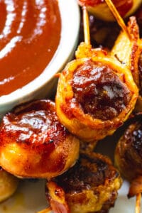 Barbecue Bacon Meatballs on a plate with bowl of bbq sauce.