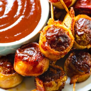 Barbecue Bacon Meatballs on a plate with bowl of bbq sauce.