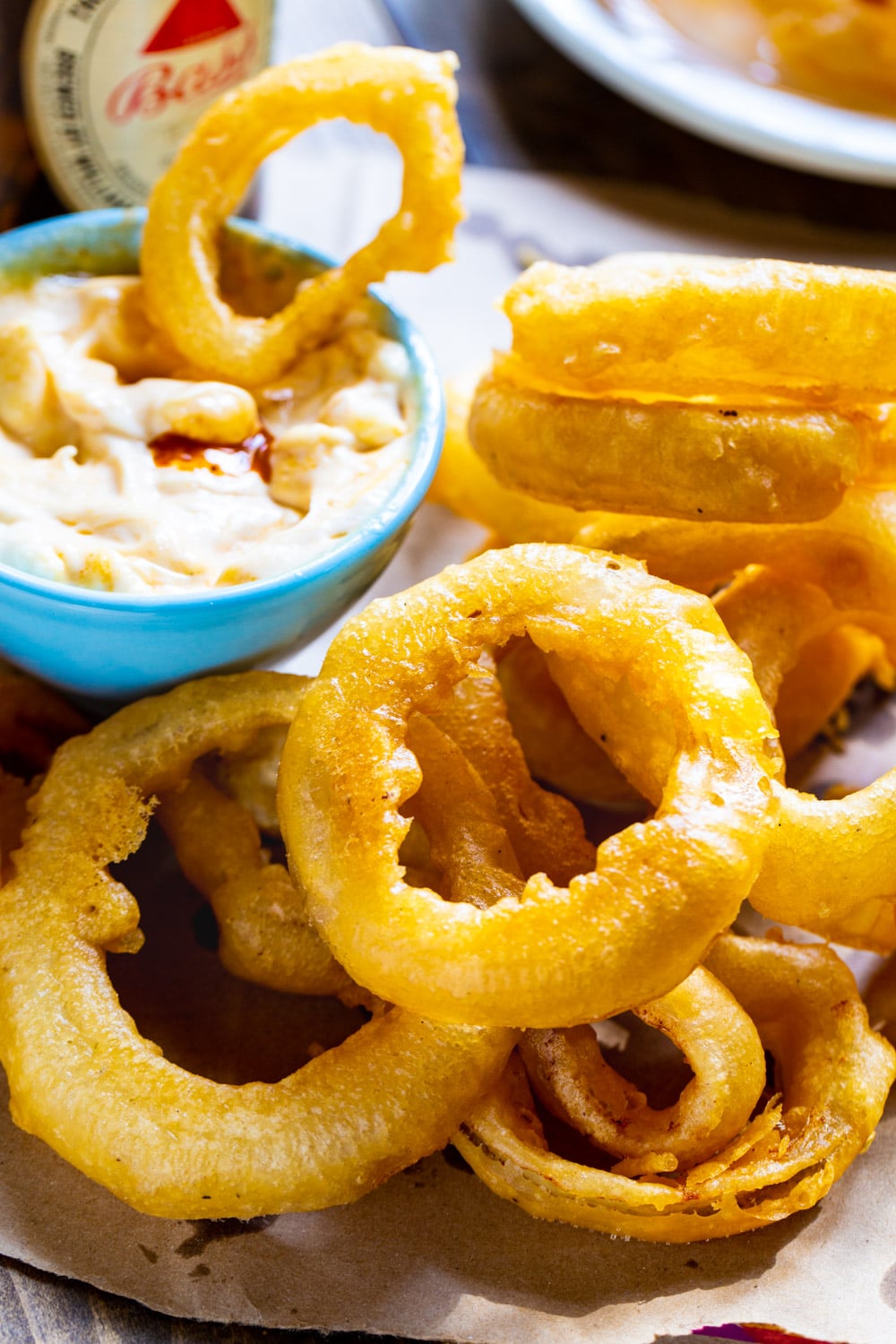 Beer Battered Onion Rings on plate with bowl of dipping sauce.