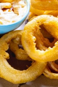 Beer Battered Onion Rings on a plate with dipping sauce.