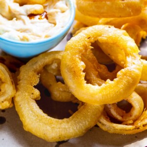 Beer Battered Onion Rings on a plate with dipping sauce.