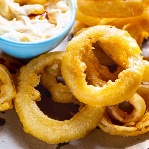 Beer Battered Onion Rings on a plate with dipping sauce.