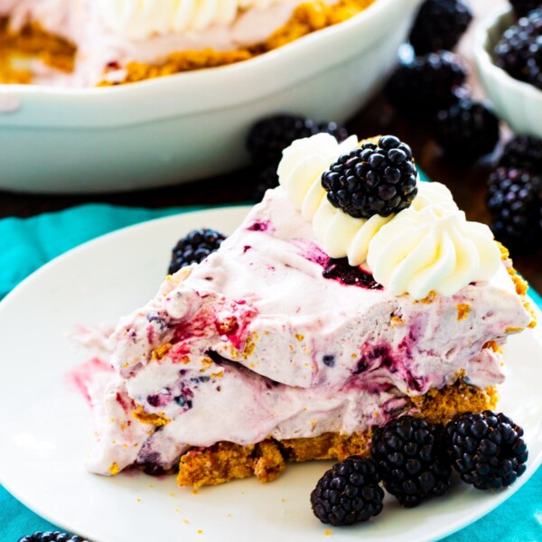 Slice of Blackberry Cheesecake Icebox Pie on a plate with fresh blackberries.