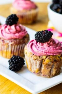 Cupcakes with Blackberries on a rectangular serving platter.