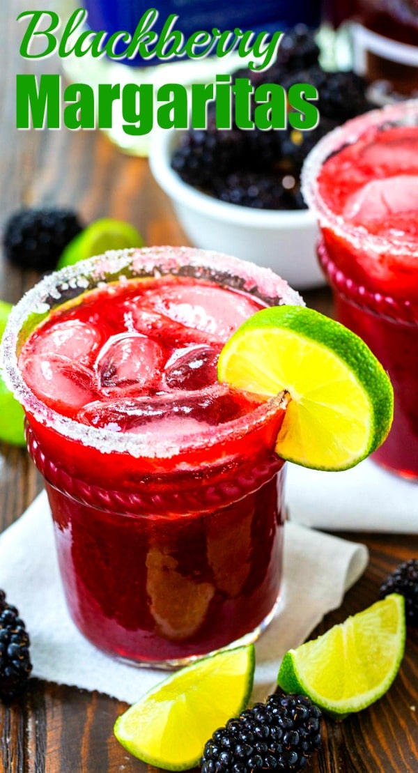 Blackberry Margaritas in a glass with lime wedges and fresh blackberries for decor.