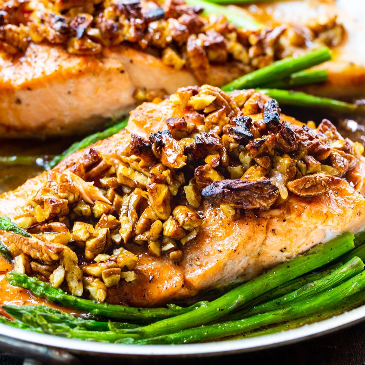 Bourbon-Pecan Glazed Salmon in a pan with asparagus