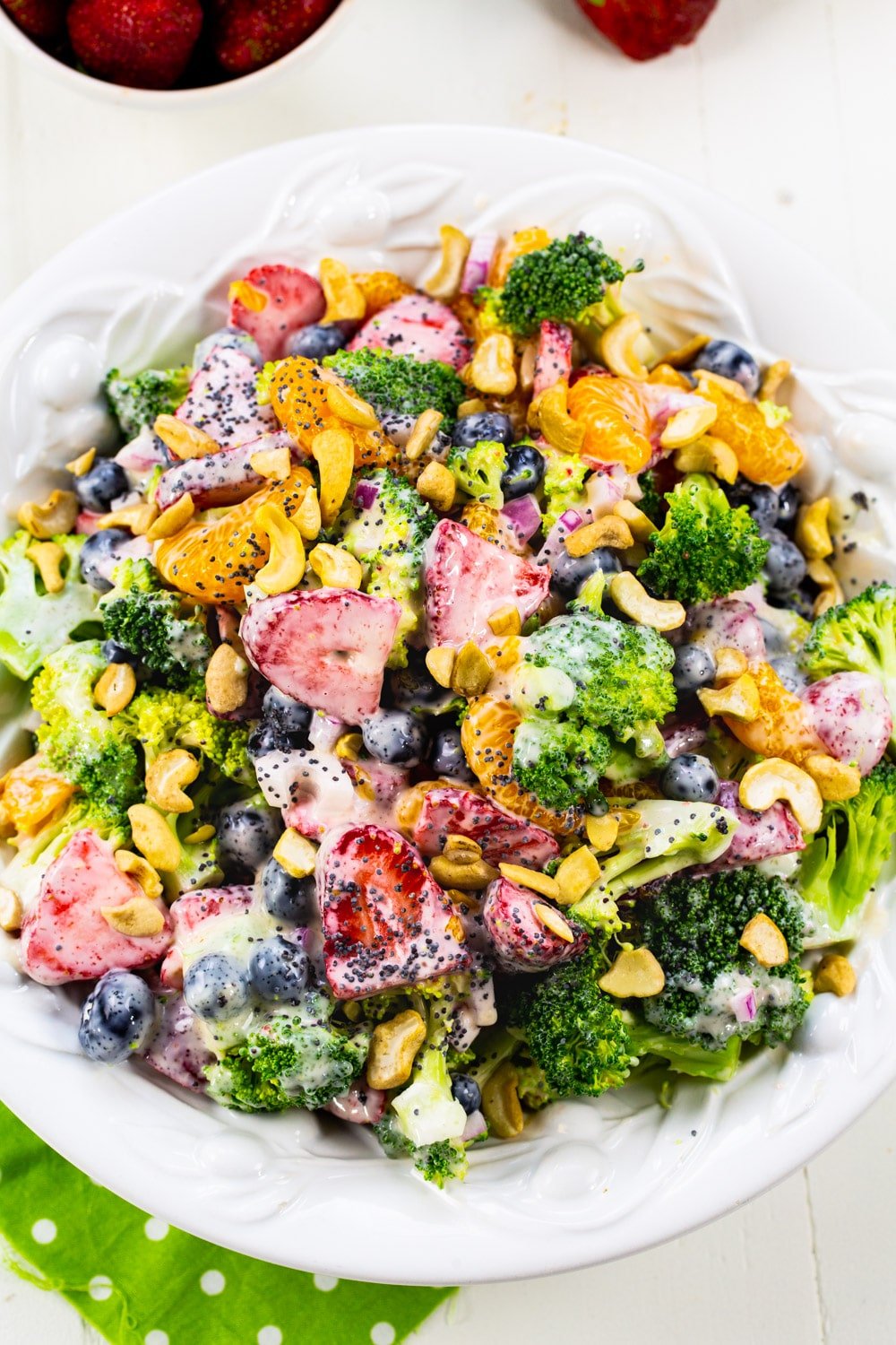 Overhead of Broccoli Salad with strawberries, blueberries, and mandarin oranges.