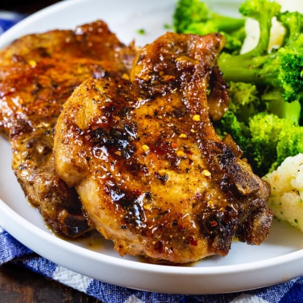 Two Brown Sugar Garlic POrk Chops on a plate with broccoli.