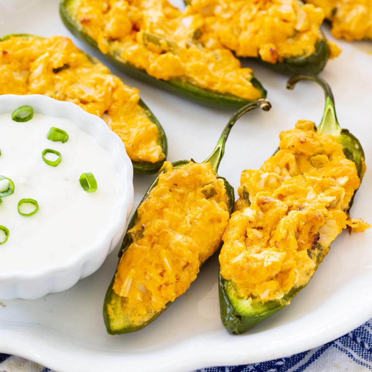 Buffalo Chicken Jalapeno Poppers on plate with bowl of blue cheese dip.