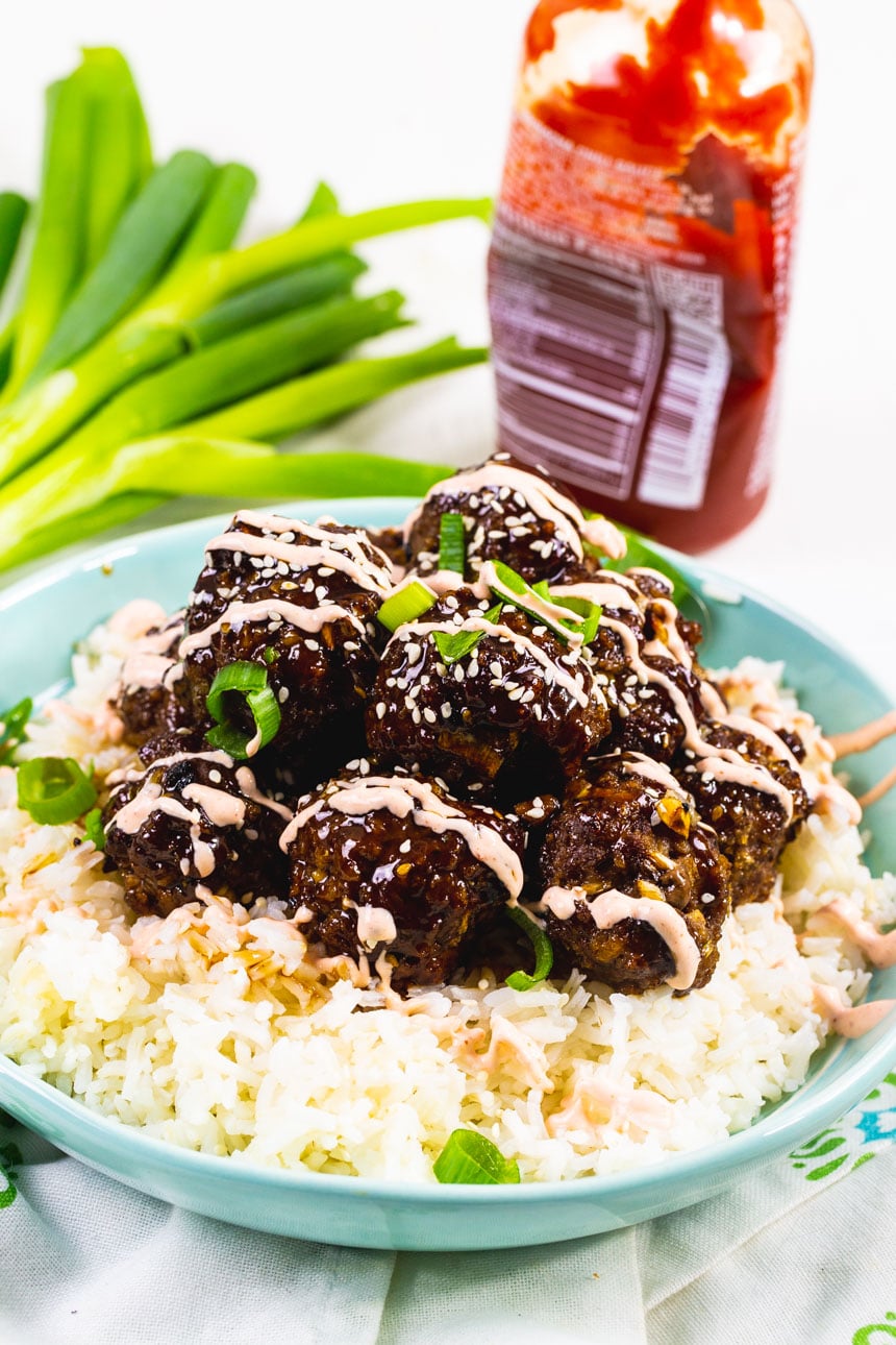 Beef Bulgogi Meatbllas over rice, drizzled with Sriracha cream sauce.