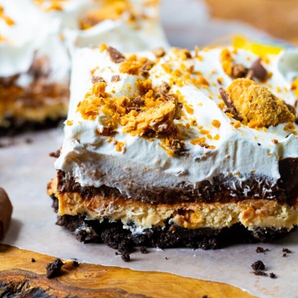 Slice of Butterfinger Chocolate and Peanut Butter Lush on a piece of parchment paper.