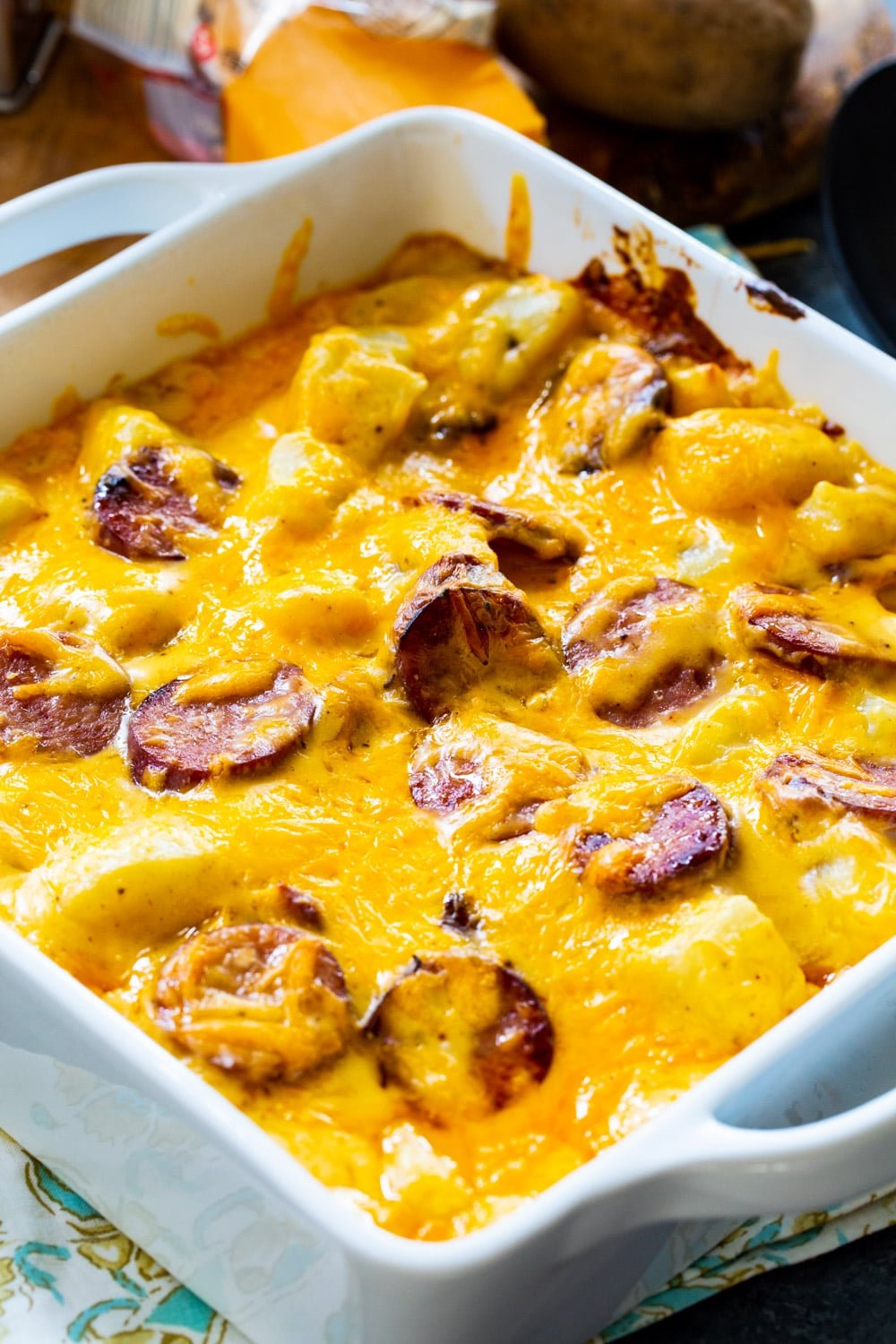 Potatoes with sausage in white baking dish.