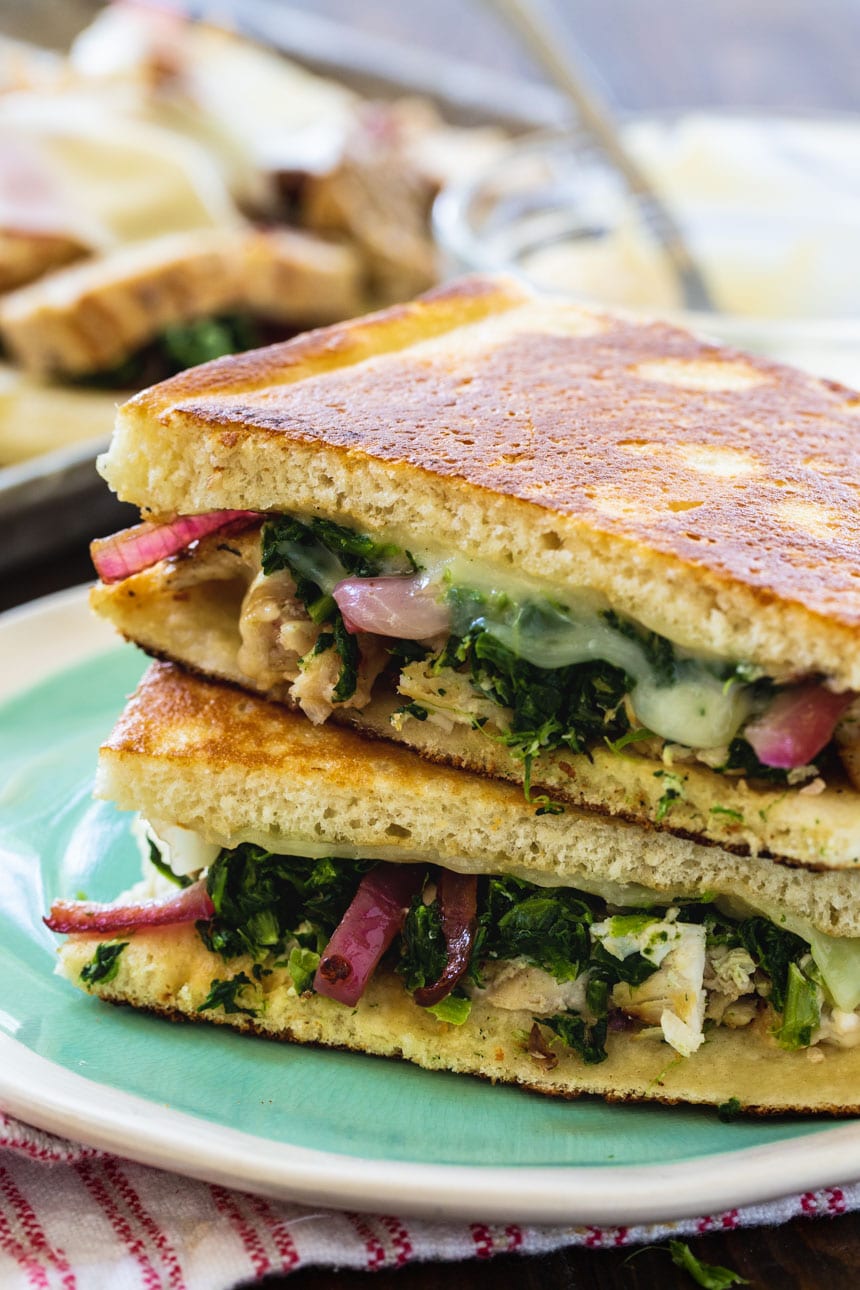 Two pieces of panini stacked on a plate.