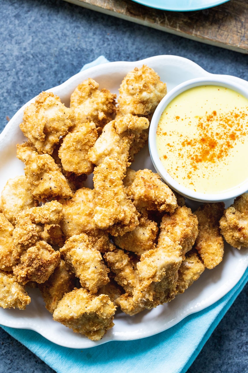 Overhead of chicken nuggets on a plate with honey mustard..