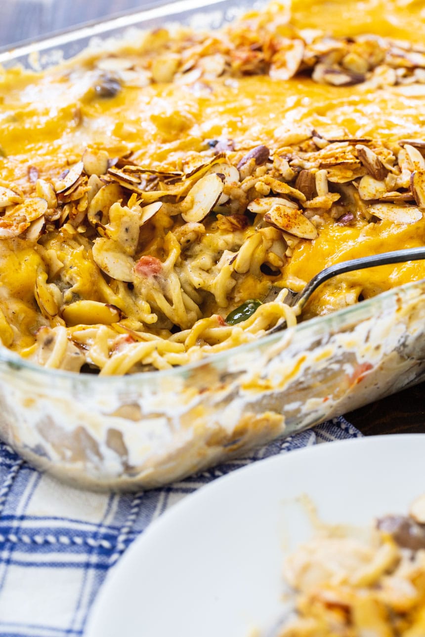 Classic Chicken Tetrazzini in a baking dish with some scooped onto a plate.