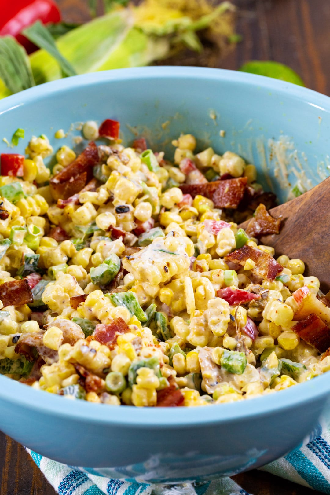 Corn Salad in blue mixing bowl with wooden spoon.