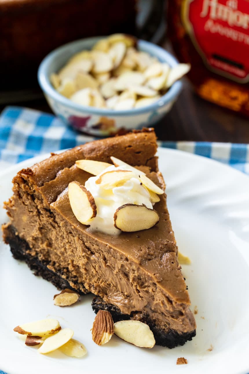 Chocolate Amaretto Cheesecake topped with whipped cream and sliced almonds.