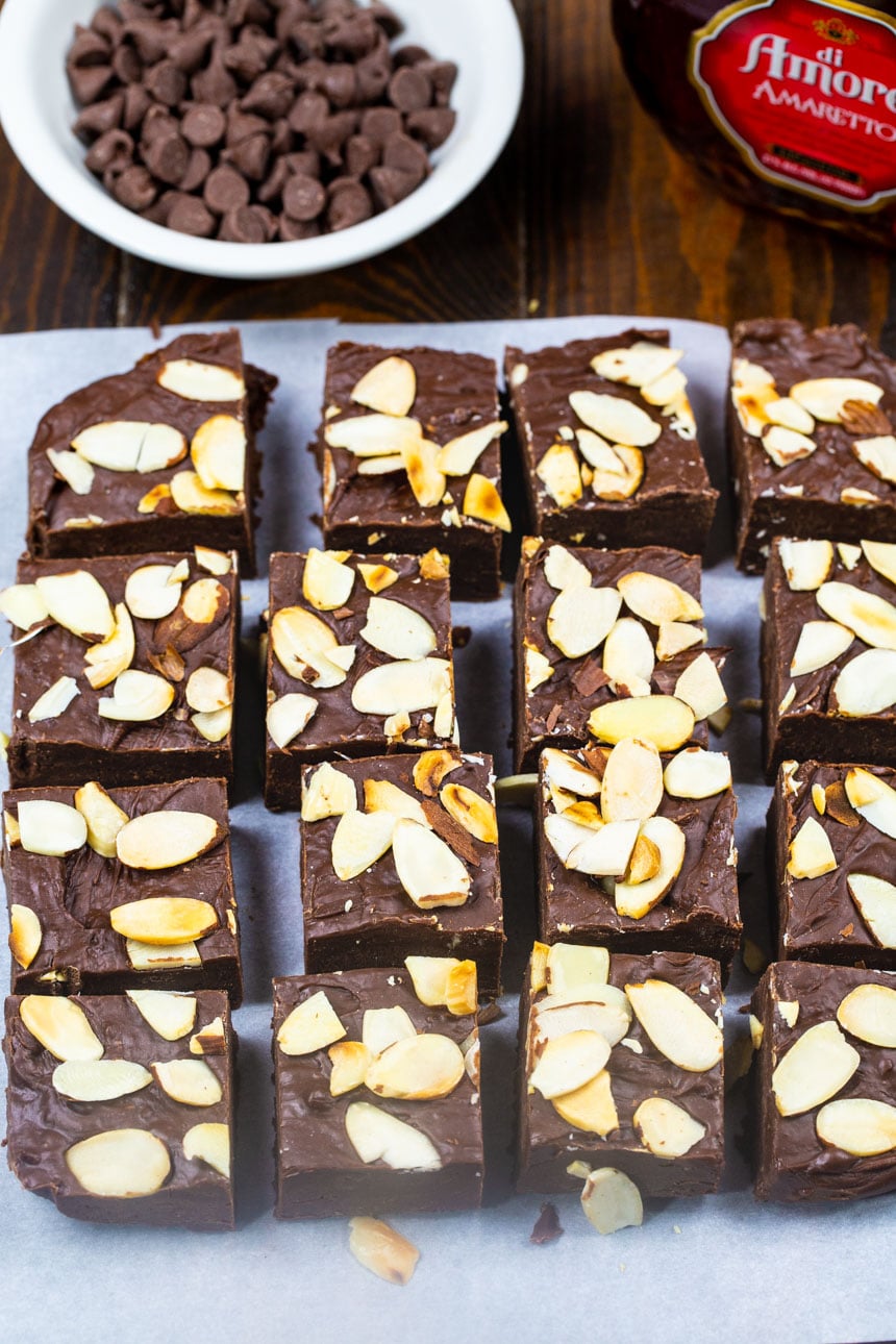 Chocolate Amaretto Fudge cut into squares with bowl of chocolate chips.