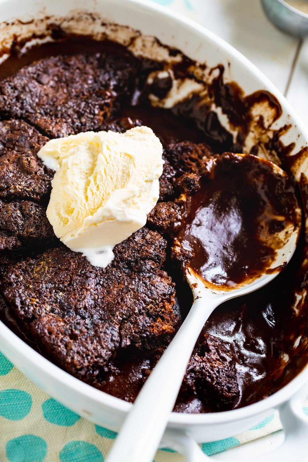 Chocolate Cobbler topped with ice cream in baking dish.
