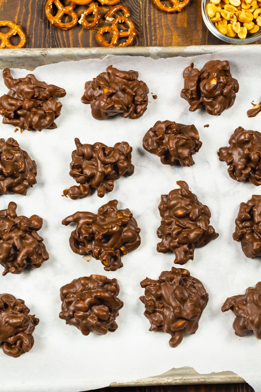Chocolate Peanut Clusters with Pretzels on a baking sheet.