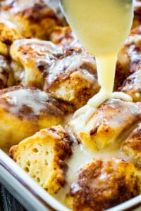 Spoon drizzling icing on Cinnamon Roll Bites
