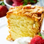 Slice Of Classic Southern Pound Cake with whipped cream and a strawberry.