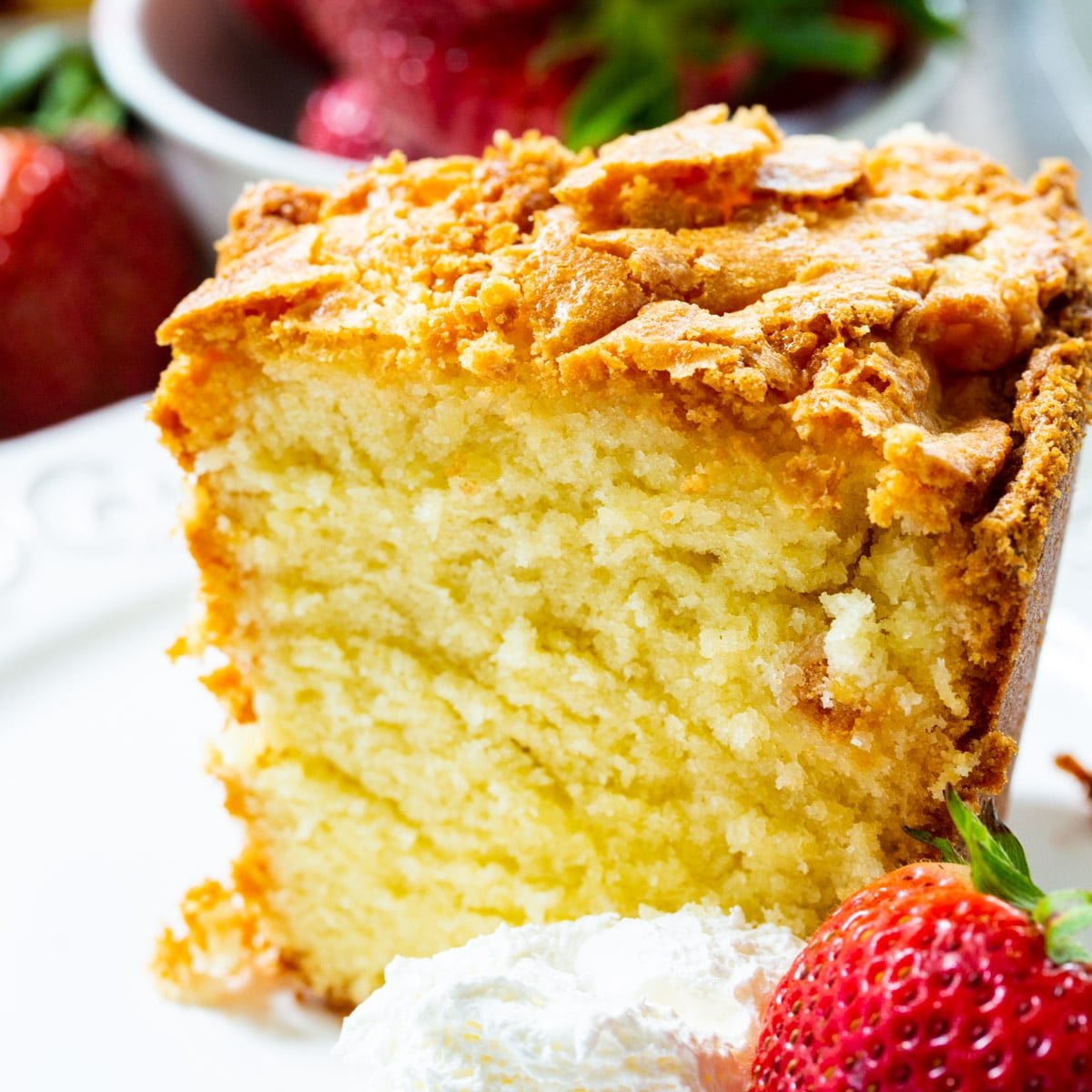 Slice Of Classic Southern Pound Cake with whipped cream and a strawberry.