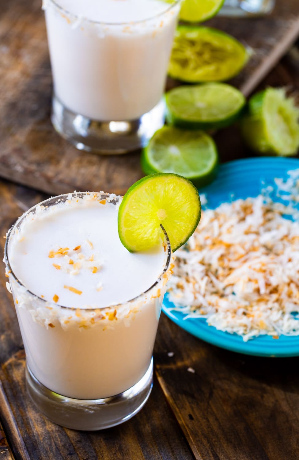 Margarita in aglass with plate of toasted coconut.