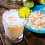 Coconut Margarita in a glass with toasted coconut around rim.