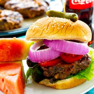 Cola Burgers topped with tomatoes, and red onions.