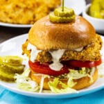 Cornflake Crusted Chicken Sandwich on a plate with dill pickle slices.