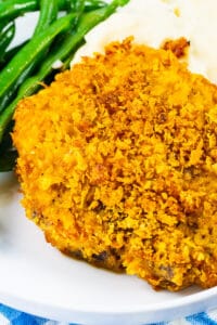 Cornflake Crusted Baked Pork Chops on plate with mashed potatoes and green beans.
