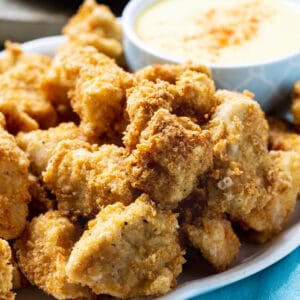 Crispy Chicken Nuggets on a plate with bowl of honey mustard dipping sauce.