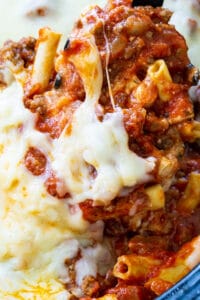 Spoon scooping Crock Pot Baked Ziti out of slow cooker.