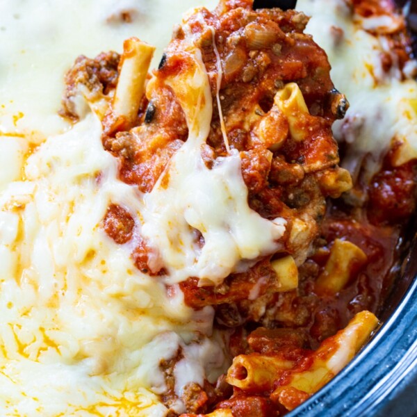 Spoon scooping Crock Pot Baked Ziti out of slow cooker.