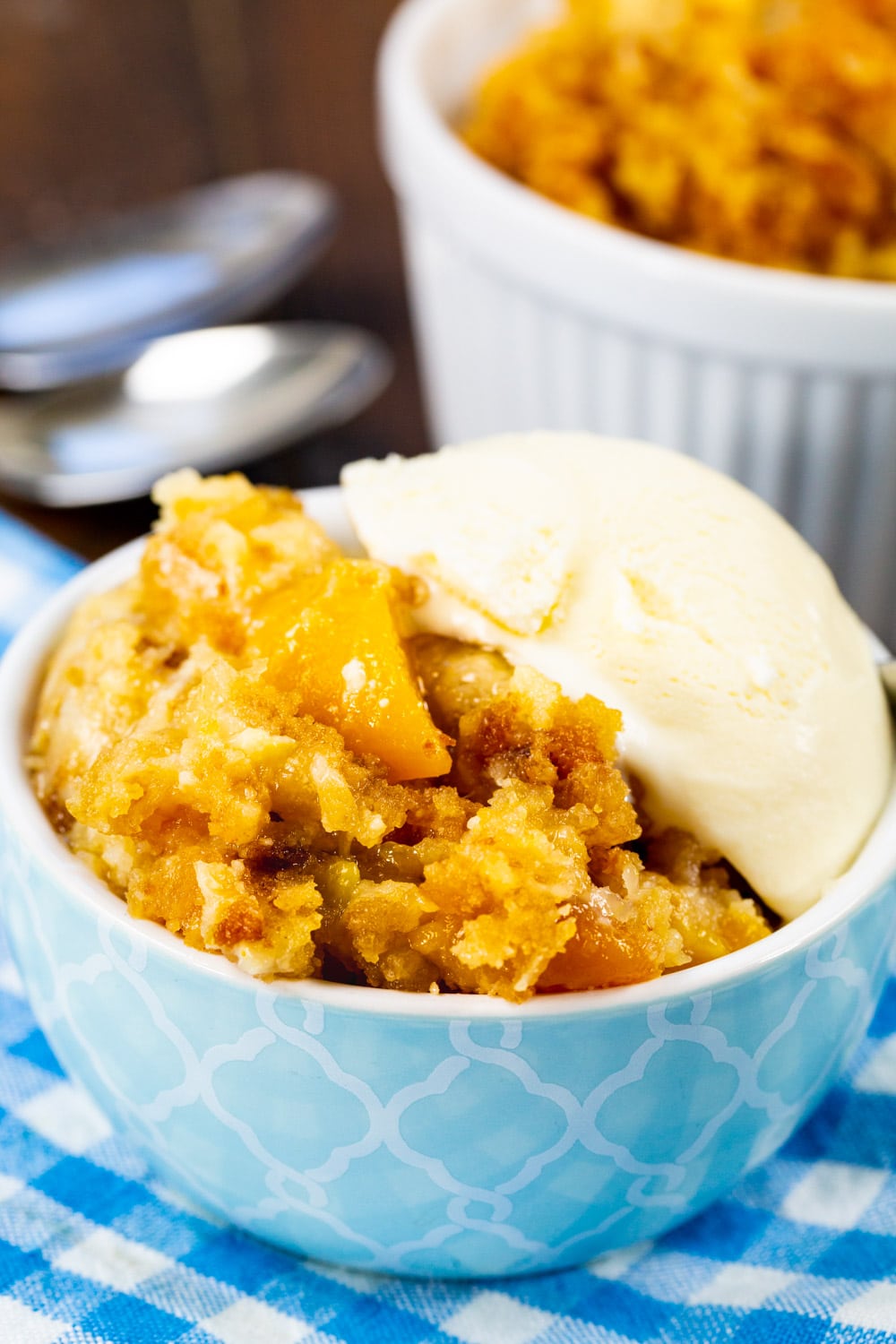 Peaches and Cream Cake topped with ice cream in a bowl.