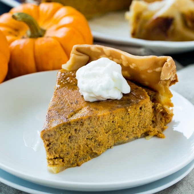 Slice of Crock Pot Pumpkin Pie topped with whipped cream.