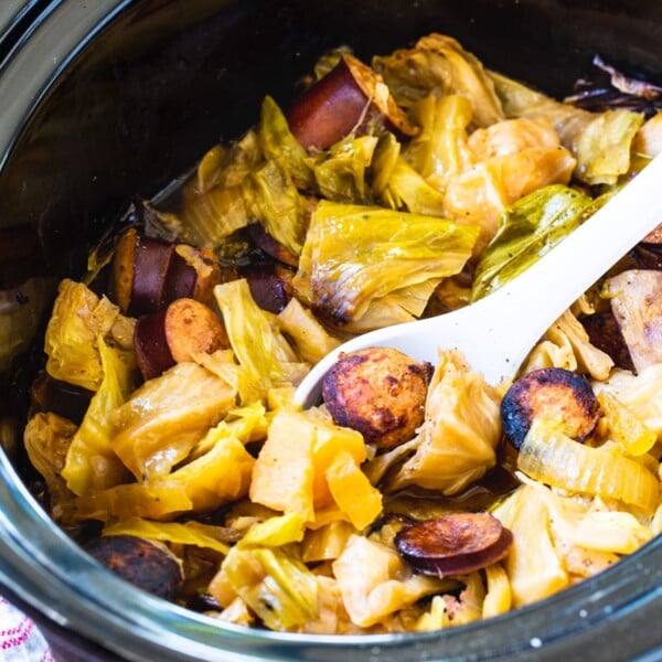 Crock Pot Cabbage and Kielbasa in black slow cooker.