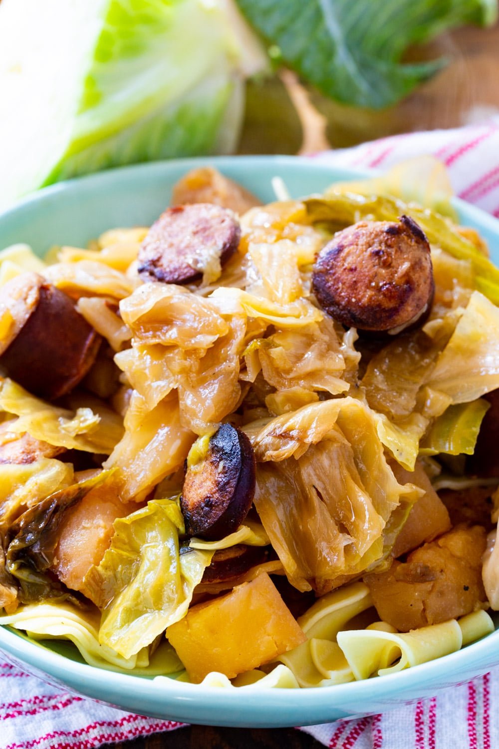 Cabbage and Kielbasa over noodles in bowl.