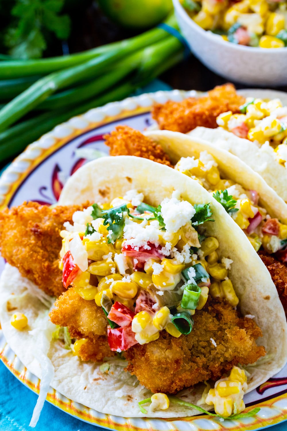 Tacos topped with Tequila Creamed Corn on a plate.