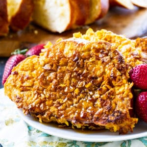Crunchy French Toast on a plate with raspberries.