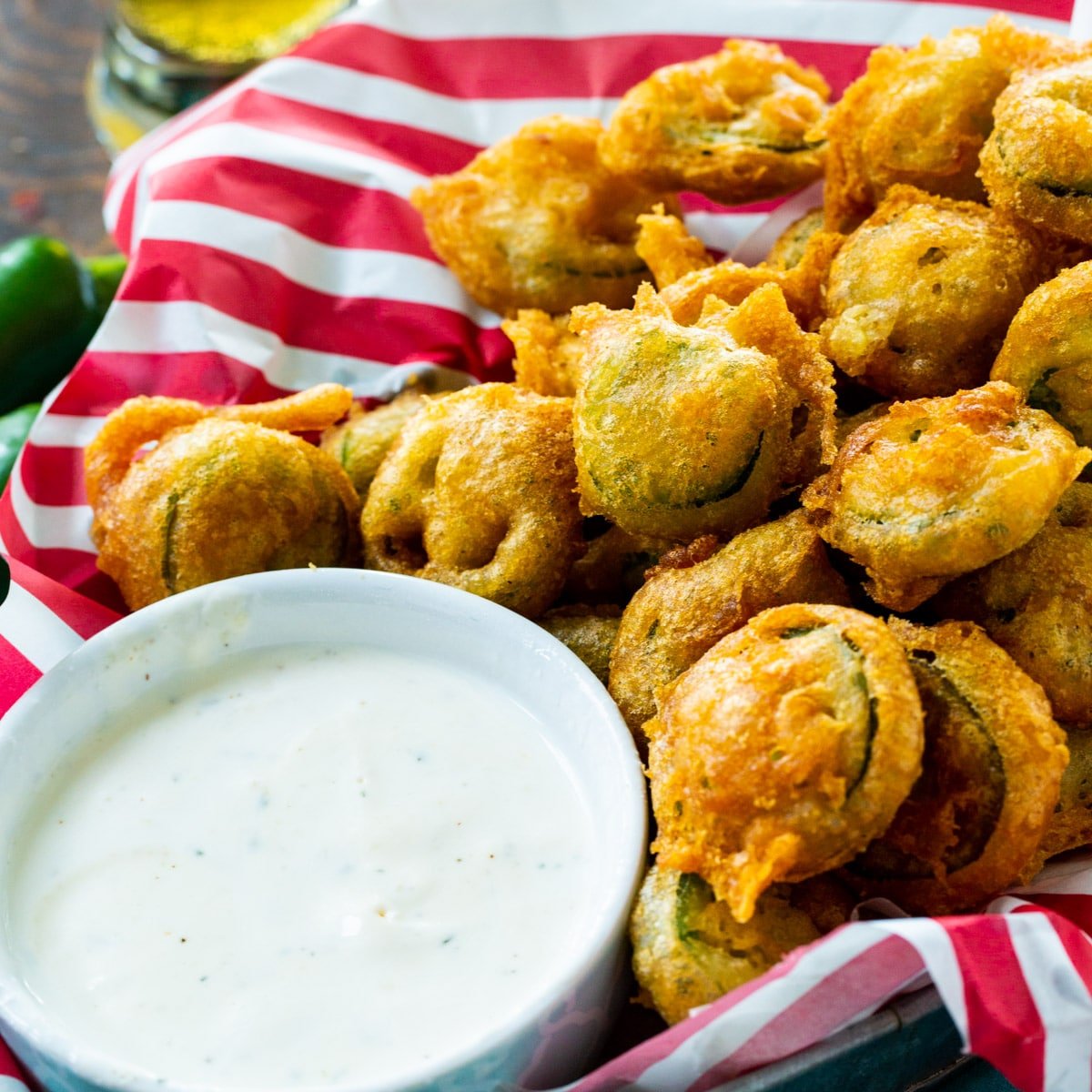 Deep Fried Jalapeno Slices in a basket with small bowl of Ranch dressing.
