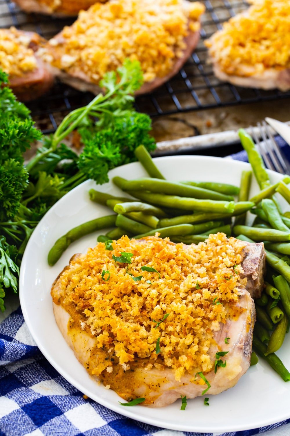 Deviled Pork Chop on a plate with green beans.