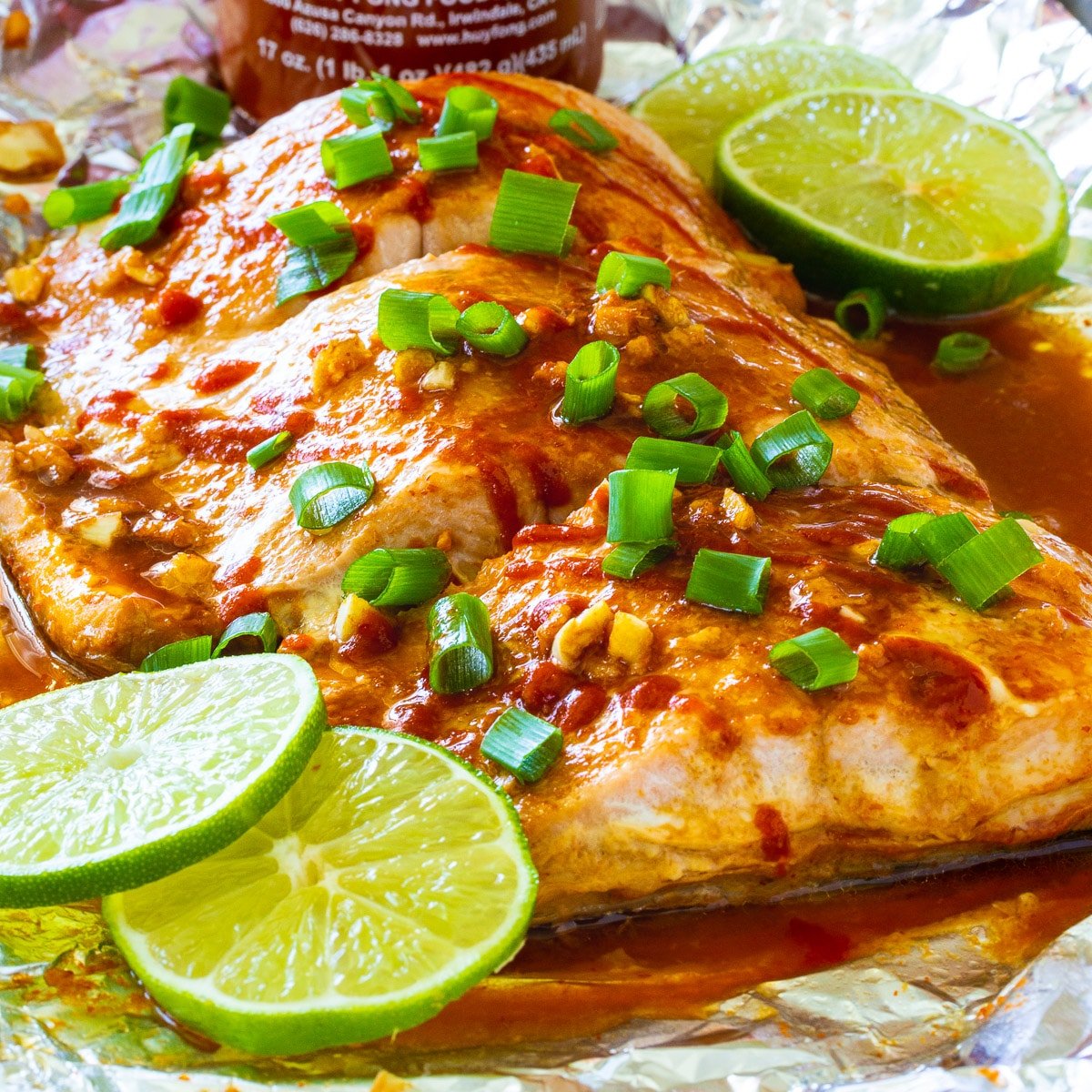 Firecracker Baked Salmon with lime slices on a baking sheet.